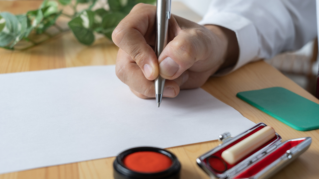 書類に記入や捺印をしている人物