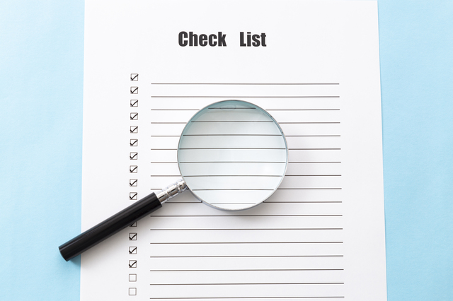 「Check List」と書かれた用紙の上に置かれた虫眼鏡