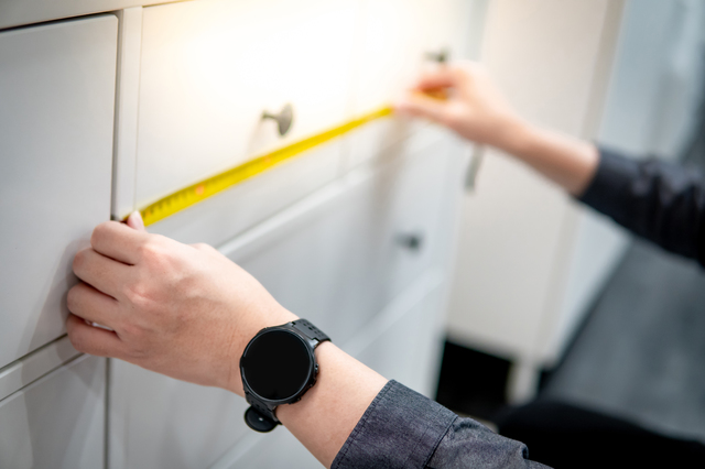 白いチェストの横幅をメジャーで正確に測っている様子